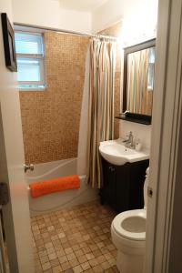 a bathroom with a toilet and a sink and a shower at Ray's Bucktown Bed and Breakfast in Chicago