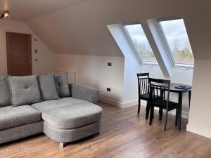 uma sala de estar com um sofá e uma mesa em Berryfield Holiday Apartment em Inverness