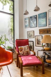a living room with a red chair and a lamp at Ray's Bucktown Bed and Breakfast in Chicago