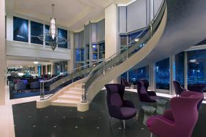 a spiral staircase in a building with purple chairs at The Westin Melbourne in Melbourne