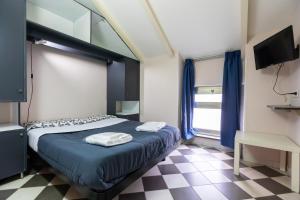 a bedroom with a bed and a tv and a checkered floor at Fabric Hostel in Portici