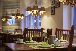 comedor con mesa de madera y sillas en Bernstein-Hotel Bootshaus, en Büsum