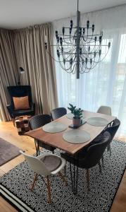 a dining room table with chairs and a chandelier at Bridge Apartment & Spa in Dziwnów