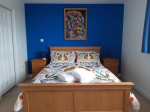 een slaapkamer met een bed met een blauwe muur bij Spacious, self-contained, 1 bedroomed annex in Bempton