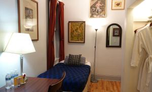 a room with a bed and a table and a lamp at Ray's Bucktown Bed and Breakfast in Chicago