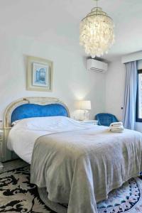 sypialnia z dużym łóżkiem i żyrandolem w obiekcie Villa Dos Palomas on the Golden Mile in Marbella w Marbelli +27 zdjęć