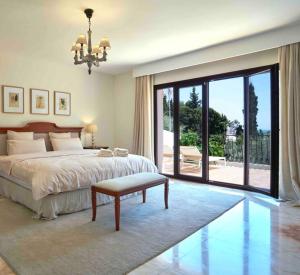 sypialnia z łóżkiem i dużymi przesuwnymi szklanymi drzwiami w obiekcie Villa Dos Palomas on the Golden Mile in Marbella w Marbelli
