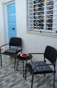 Pokój z 2 krzesłami, stołem i oknem w obiekcie Chez Ayedi - central and familiar atmosphere next to beach w mieście Hammam-Plage