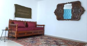 a living room with a red couch and a mirror at Chez Ayedi - central and familiar atmosphere next to beach in Hammam-Plage