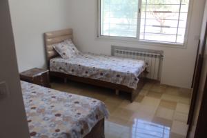 a room with two beds and a chair and a window at Relaxing Vacation Stay in Mahdia in Rejiche