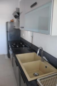 a kitchen with a sink and a stove at Relaxing Vacation Stay in Mahdia in Rejiche