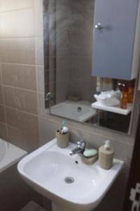 ein Bad mit einem Waschbecken und einem Spiegel in der Unterkunft Relaxing Vacation Stay in Mahdia in Rejiche