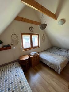 1 Schlafzimmer mit 2 Betten, einem Tisch und einem Fenster in der Unterkunft Domek letniskowy Opowieści z Narie Kretowiny in Kretowiny