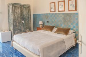 サン・ニコーラ・アルチェッラにあるLa casa nel borgoの青いタイル張りの壁、ベッドルーム1室(ベッド1台付)