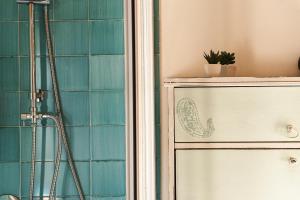 聖尼科拉阿爾切拉的住宿－La casa nel borgo，浴室铺有蓝色瓷砖,设有淋浴。