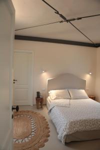 Agriturismo I Casali في Fiumaretta di Ameglia: غرفة نوم بسرير ابيض وسجادة