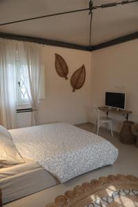 Agriturismo I Casali في Fiumaretta di Ameglia: غرفة نوم مع سرير ومكتب مع الكمبيوتر المحمول