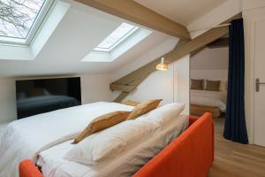 a bedroom with a bed with an orange couch at Villa Forestière Appart Le Cèdre in Quincy-Voisins