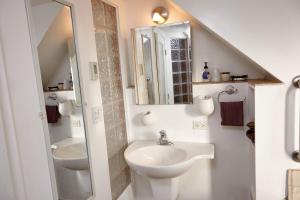 a white bathroom with a sink and a mirror at Ray's Bucktown Bed and Breakfast in Chicago