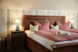 a bedroom with a bed with red and white pillows at Bernstein-Hotel Bootshaus in Büsum