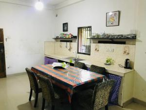 een keuken met een tafel met stoelen en een wastafel bij Menara Villa in Kamburugamuwa