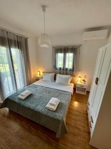 una camera da letto con un grande letto con due asciugamani di My Bright House ad Áfitos