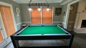 a room with a pool table in a room with windows at Red Door North Jackson-Ridgeland Vacation Home in Jackson