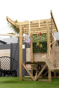a pergola with a hammock and a bench at Le gîte suspendu et sa chambre cachée in Saint-Blimont