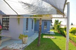 a house with a palm tree in the yard at acaciaoptimumstay in Gaborone