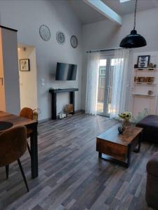 uma sala de estar com um sofá, uma mesa e uma lareira em Gite & Spa Au pommier fleuri et son "Appart" indépendant em Drusenheim
