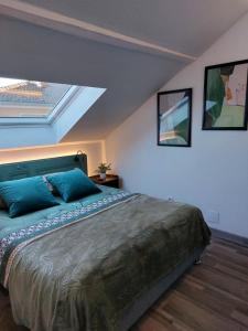 a bedroom with a bed with blue pillows on it at Gite & Spa Au pommier fleuri in Drusenheim