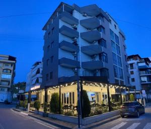 un bâtiment avec une voiture garée devant lui dans l'établissement Hotel RivierA, à Durrës