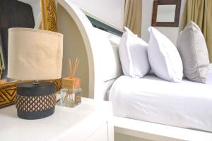 a bedroom with a bed with white pillows at acaciaoptimumstay in Gaborone