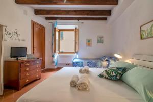 una camera da letto con un grande letto con asciugamani di DeRy Alghero Holiday Gilbert ad Alghero