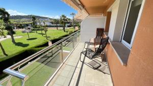 balcón con 2 sillas y vistas a un parque en La Bovila Apartment with exceptional yard, en Platja d'Aro