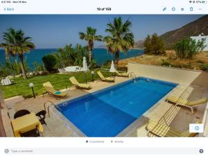 a swimming pool with chairs and a view of the ocean at Kallinousa Beach Villa in Pomos