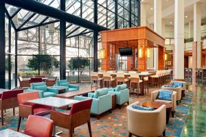 a lobby with tables and chairs and a television at The Westin Atlanta Airport in Atlanta