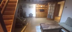 a living room with stairs and a couch and a table at Plumpton Barn in Ashford