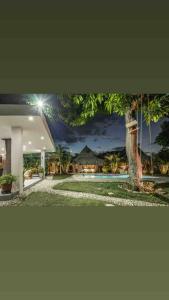a picture of a house at night with a tree at Villa el Oasis, luxurious Santa Marta getaway in Santa Marta