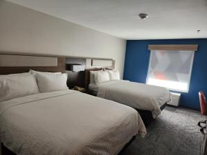 Holiday Inn Express & Suites Perry, an IHG Hotel في Perry: غرفة فندقية بسريرين ونافذة