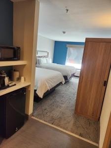 a room with two beds and a kitchen with a microwave at Holiday Inn Express & Suites Perry, an IHG Hotel in Perry