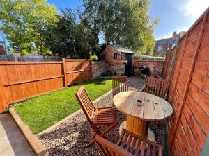 a backyard with a table and chairs and a fence at Rasen Cottage in Lincolnshire
