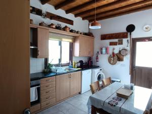 a kitchen with wooden cabinets and a table and a sink at Traditional Villa Sofia in Vrysoules