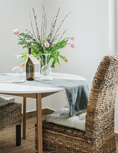 a table with a vase of flowers and two chairs at Buborék - Somló Country Home in Somlóvásárhely