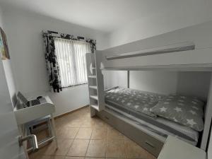 sypialnia z łóżkiem piętrowym i oknem w obiekcie Gerry&Lotti Apartment w Son Bou