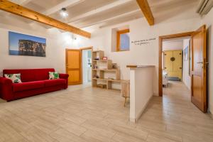 a living room with a red couch and a table at Dery Alghero Holiday La Torre in Alghero