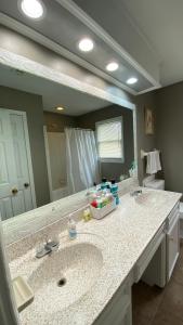 Red Door North Jackson-Ridgeland Vacation Home في جاكسون: حمام به مغسلتين ومرآة كبيرة