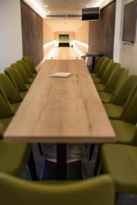 una sala de conferencias con una mesa larga y sillas verdes en Lieb&Wert en Raesfeld