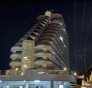 un gran edificio por la noche con luces encendidas en Rayong Condo Chain studio room, en Ban Pak Khlong Phe