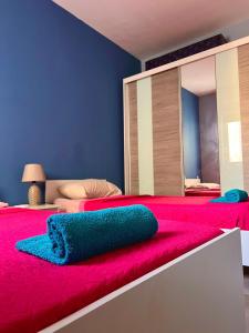 1 dormitorio con cama roja y espejo grande en New Breeze en St Paul's Bay